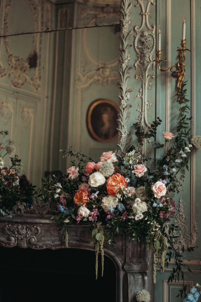 Flowers sitting on top of a mantle at the historic chateau de champlatreux in France. 