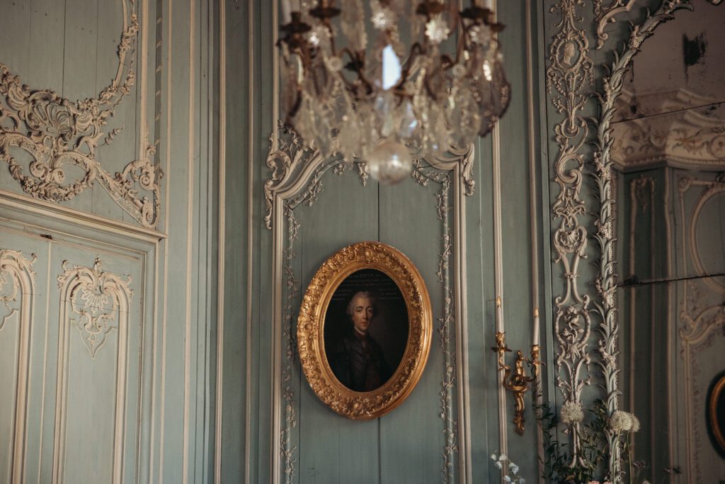 An oil painting in a gold frame at the wedding venue chateau de champlatreux in France. 