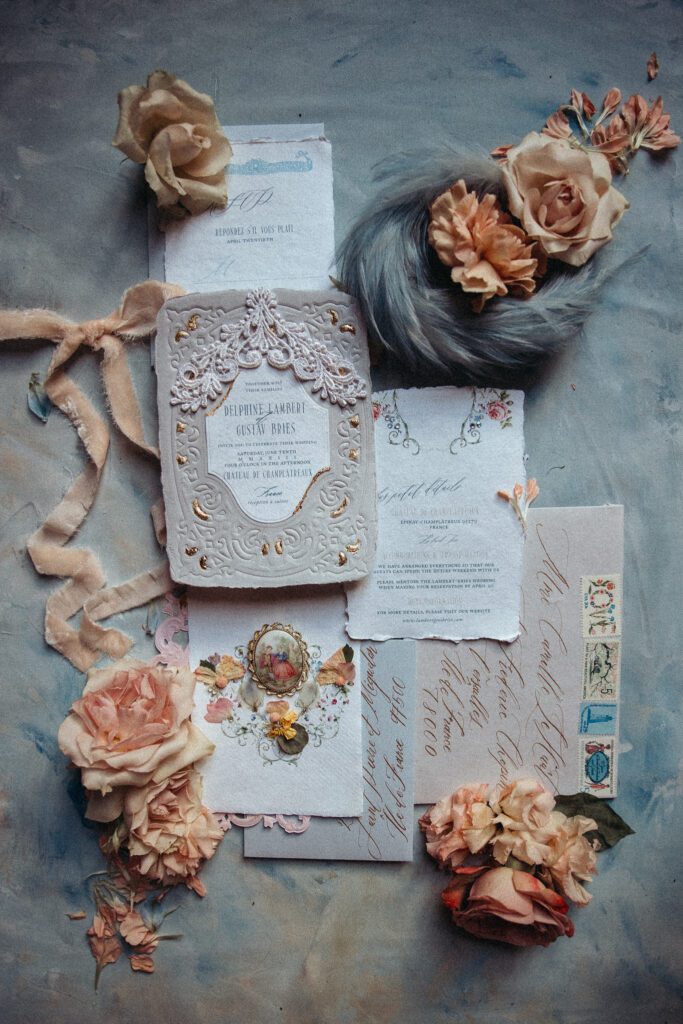 Invitation flatlay at the wedding venue Chateau de Champlatreux in France. Blue and peach details. 