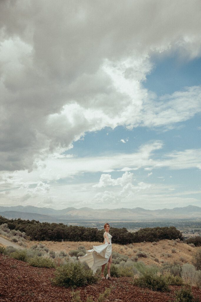 Columbus, Ohio wedding photographer traveling to Utah to photograph a bride standing before mountains twirling her dress. 