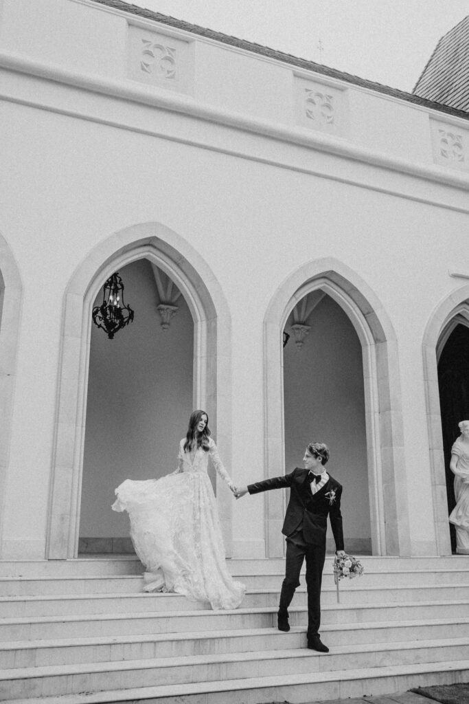 Bride following groom out of Chateau Nouvelle while they hold hands