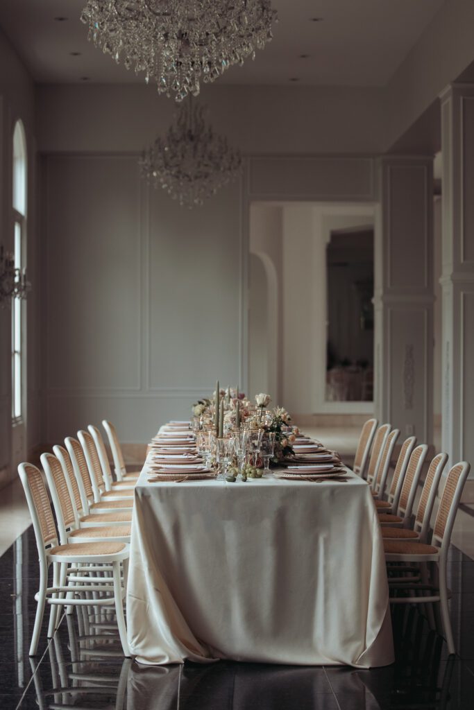 The reception area in Chaeau Nouvelle focusing on a table set for wedding guests. Neutral, elegant colors and florals. 